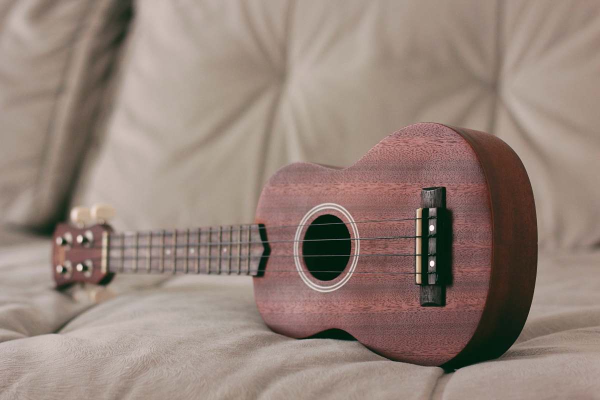 musical instrument brown ukulele on couch leisure activities